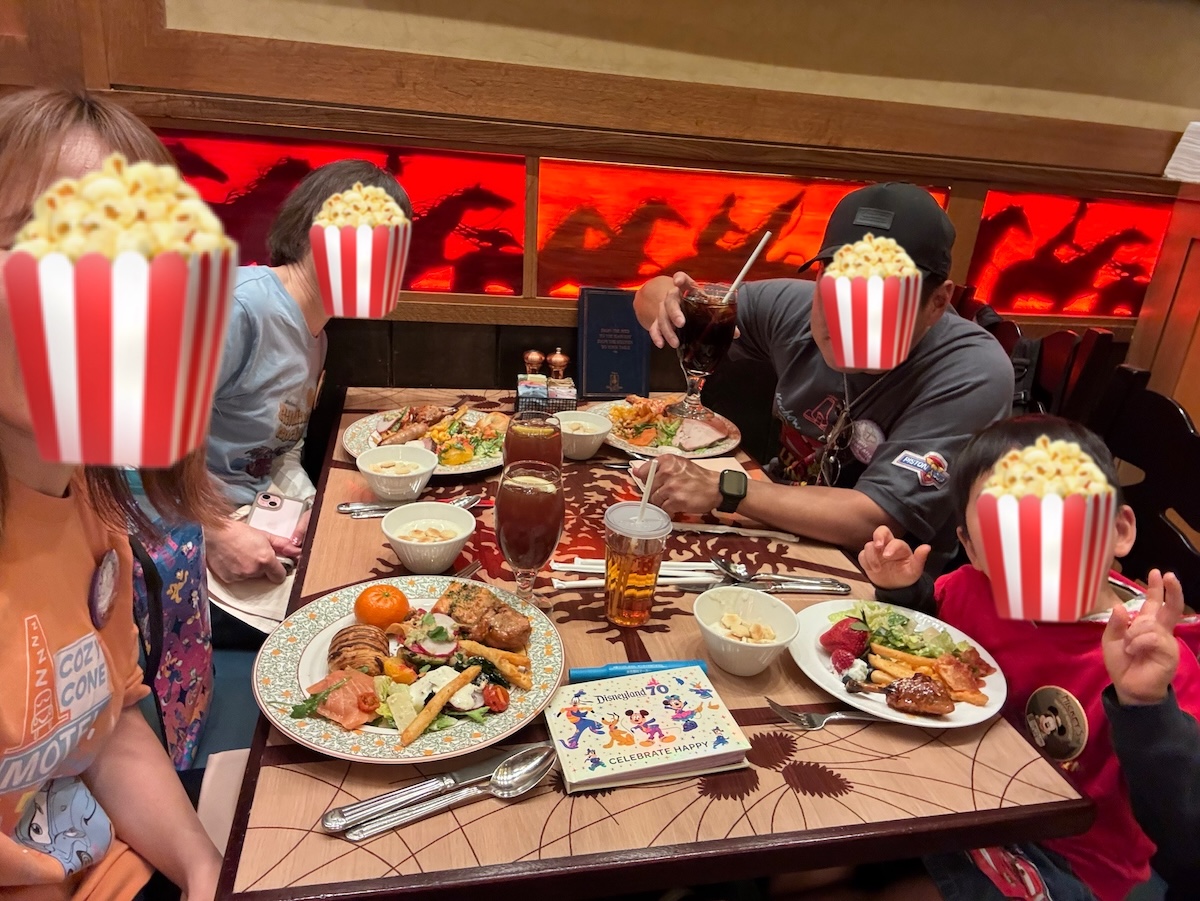 アナハイムディズニーでレストランに座って昼食をとりながら休憩する家族