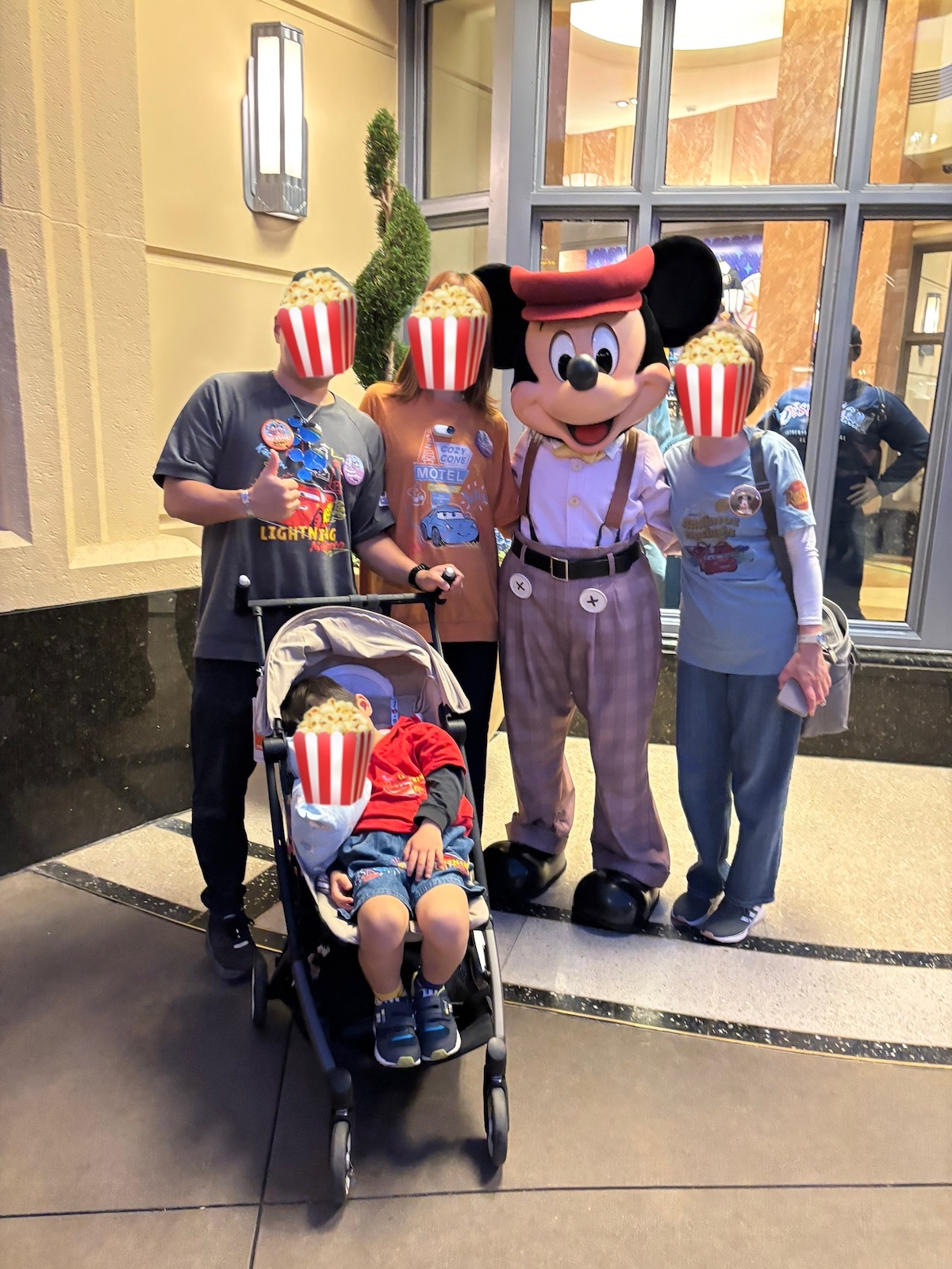 アナハイムディズニーでベビーカーに乗ったまま昼寝をしながらミッキーとグリーティングする4歳の子ども