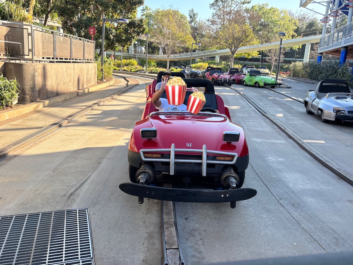 ディズニーランドのAutopiaで子供がゴーカートを運転している写真