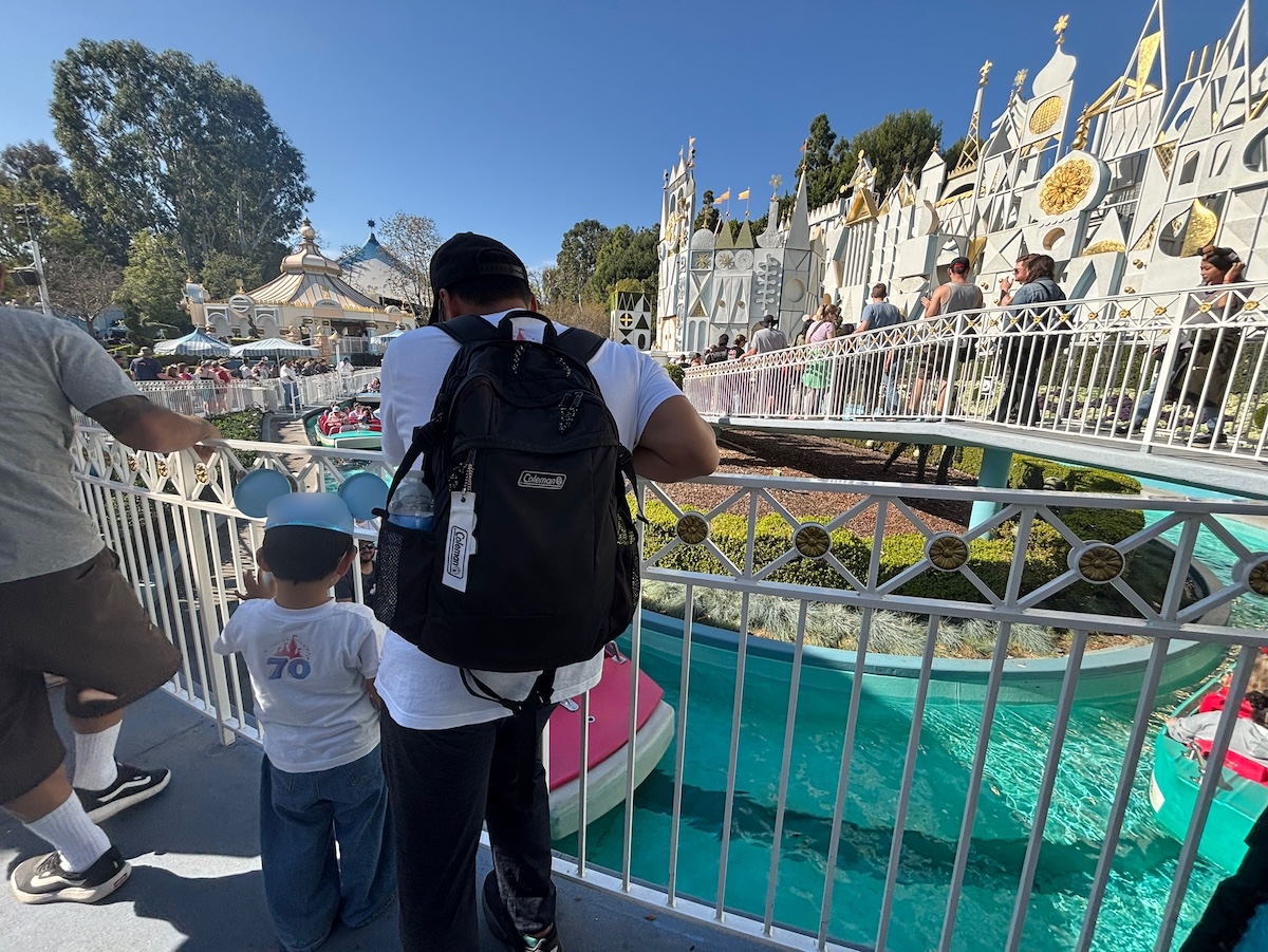 ディズニーランドの「it's a small world」外観とボートを見つめる子どもと父親