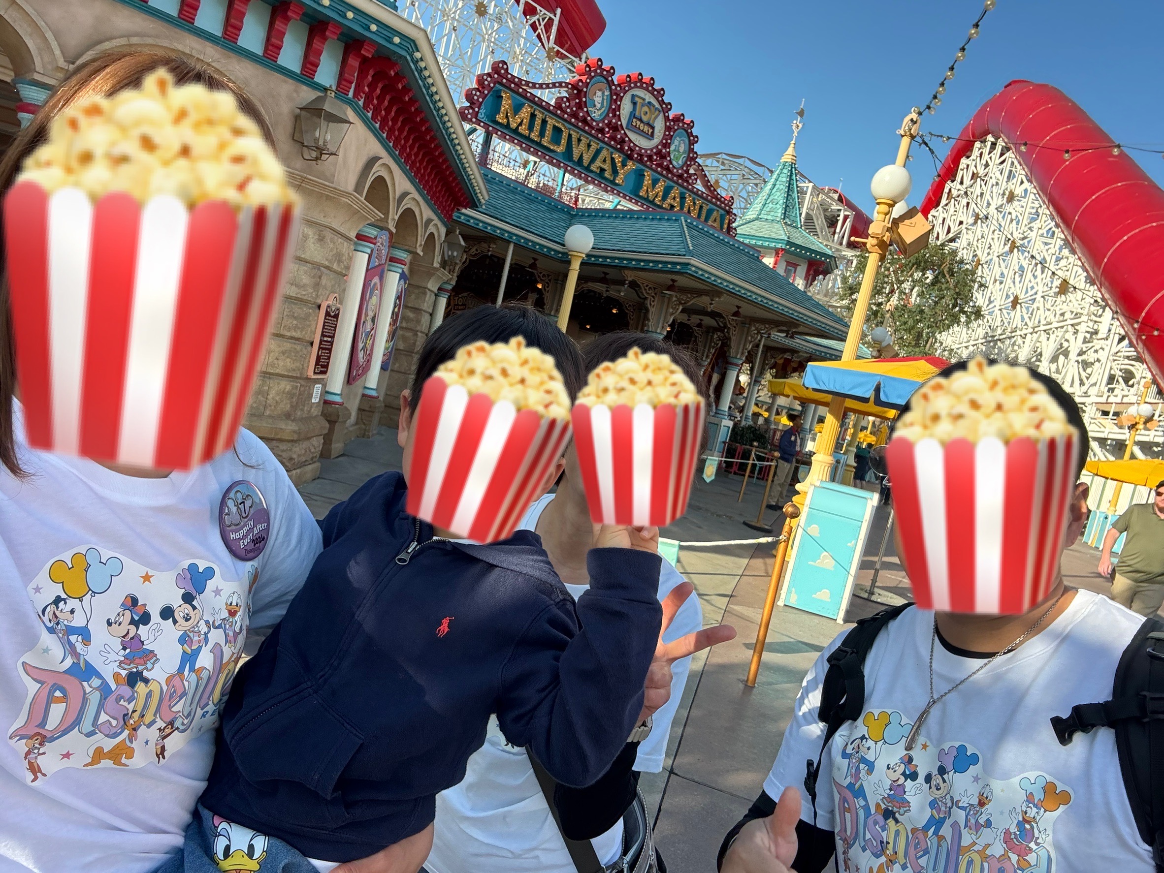 DCAの「Toy Story Midway Mania!」前で家族4人が自撮りしている写真(顔は絵文字加工)