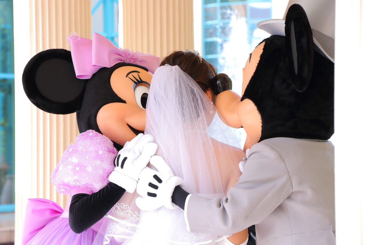 ディズニーアンバサダーホテルの結婚式でガゼボにてミッキーとミニーに挟まれてキスしてもらった写真
