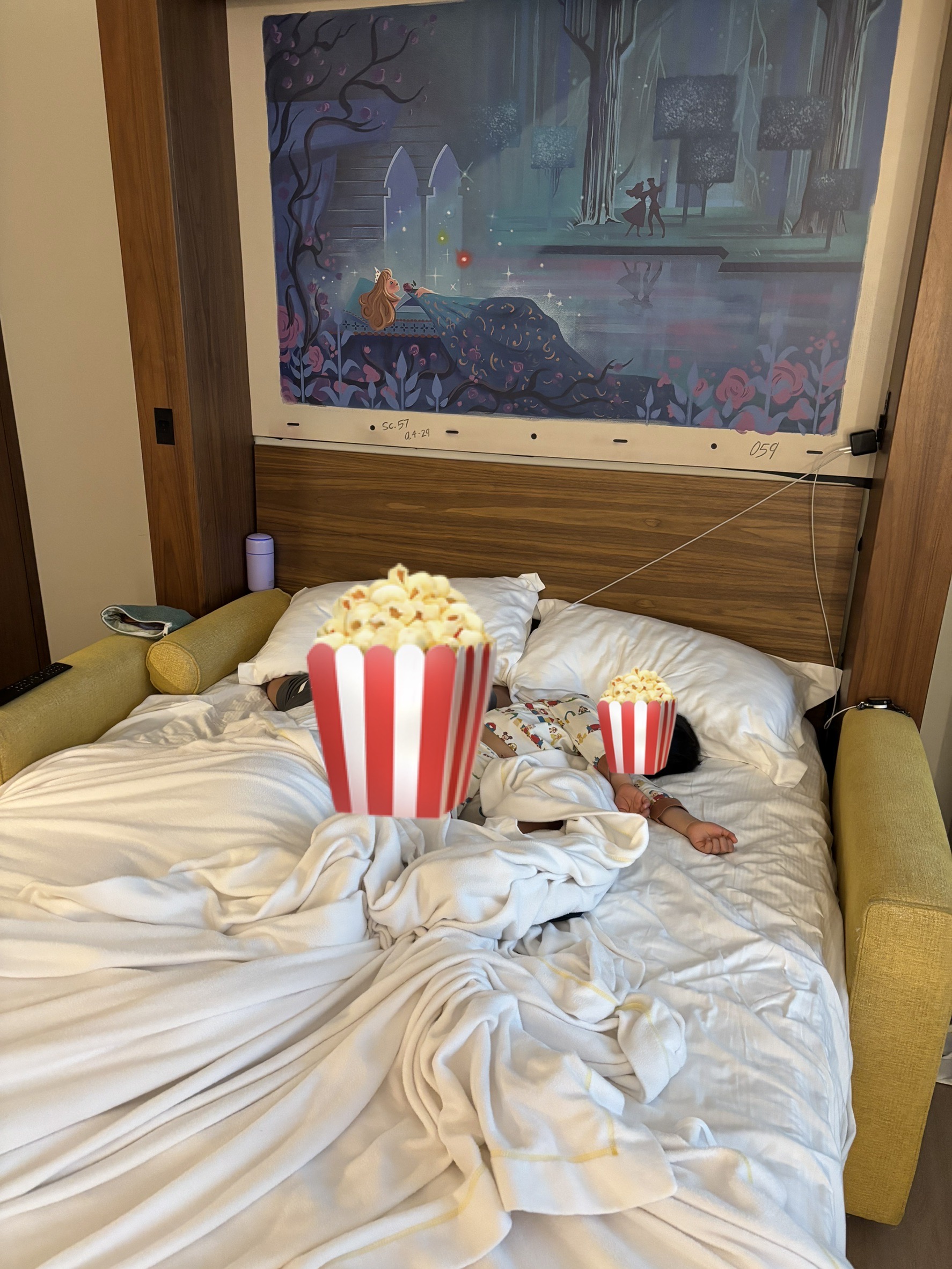 ホテルの部屋で寝る子どもと枕元の携帯用加湿器