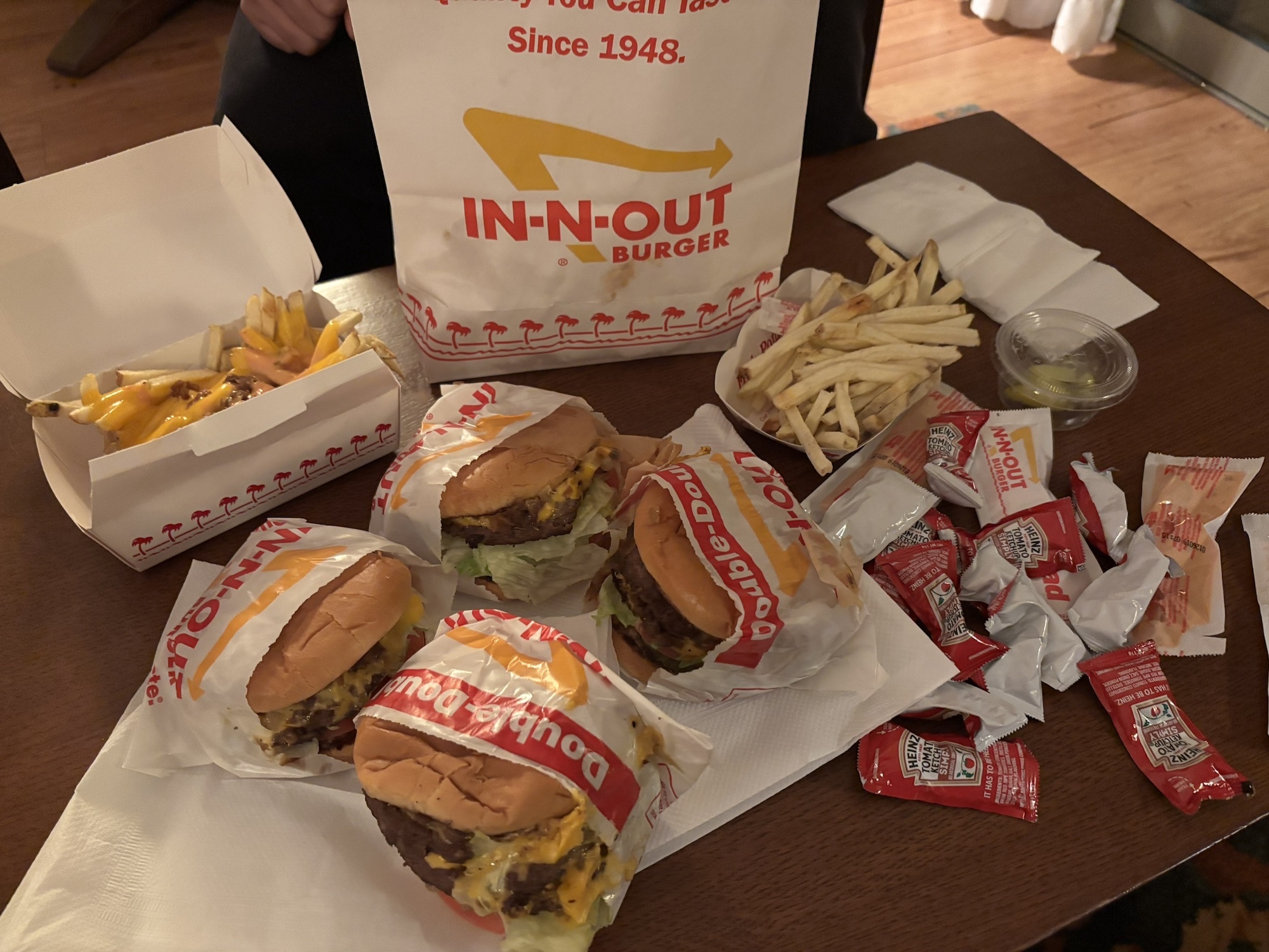 ホテルの部屋でインアンドアウトバーガーのテイクアウト品を並べた写真