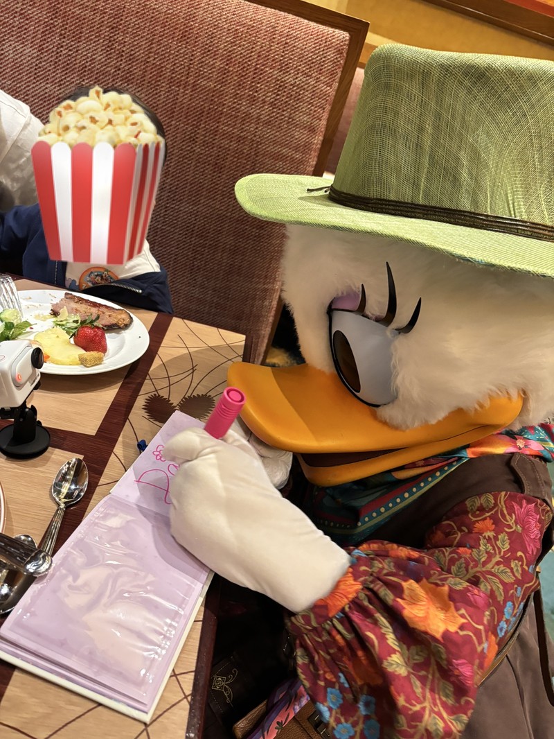 ストーリーテラーズカフェでサインを書いてくれているデイジーダックの写真
