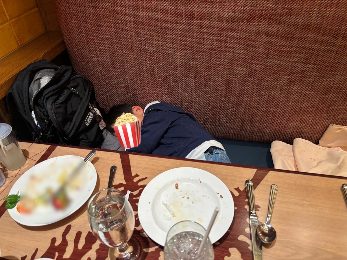 ストーリーテラーズカフェの椅子でお腹いっぱいになって寝てしまっている息子の写真