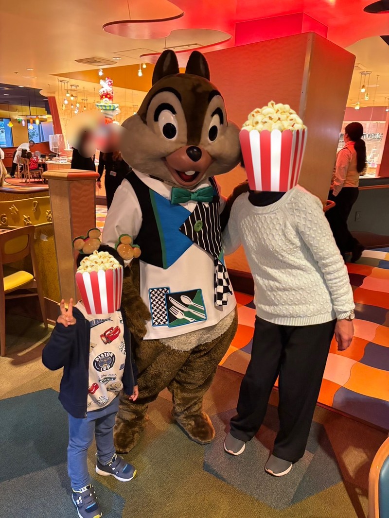 グーフィーズキッチンで緑の蝶ネクタイをつけたウエイター姿のチップと息子と祖母のグリーティング写真