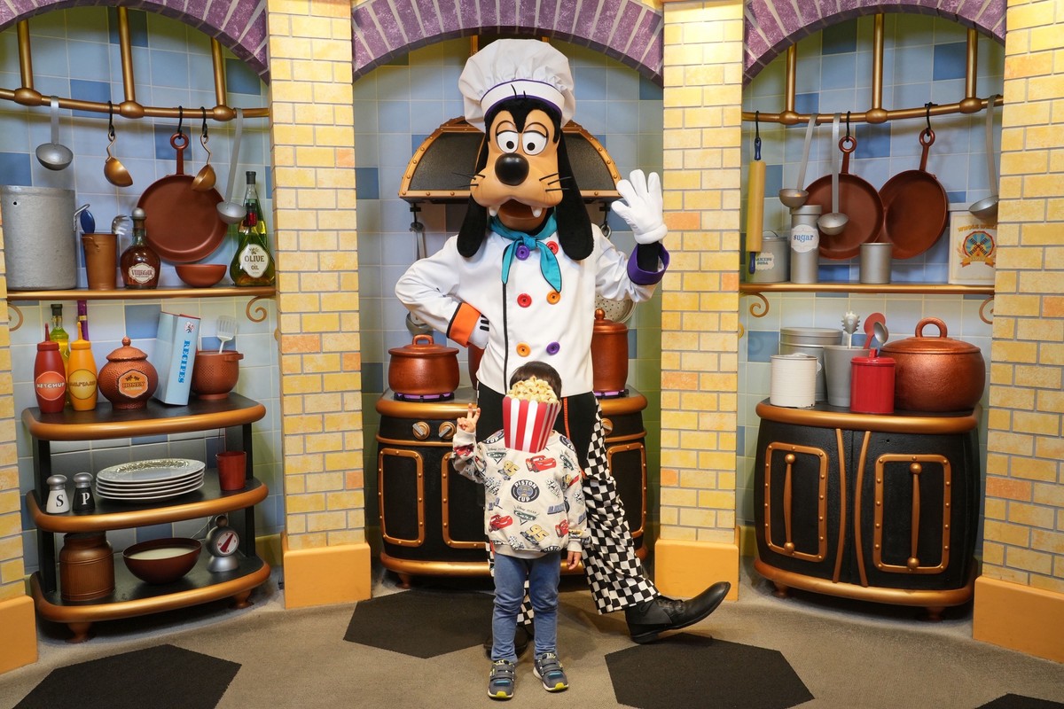 グーフィーズキッチンのフォトブースで息子とグーフィーのツーショット写真。可愛い厨房のセット全体が写っている