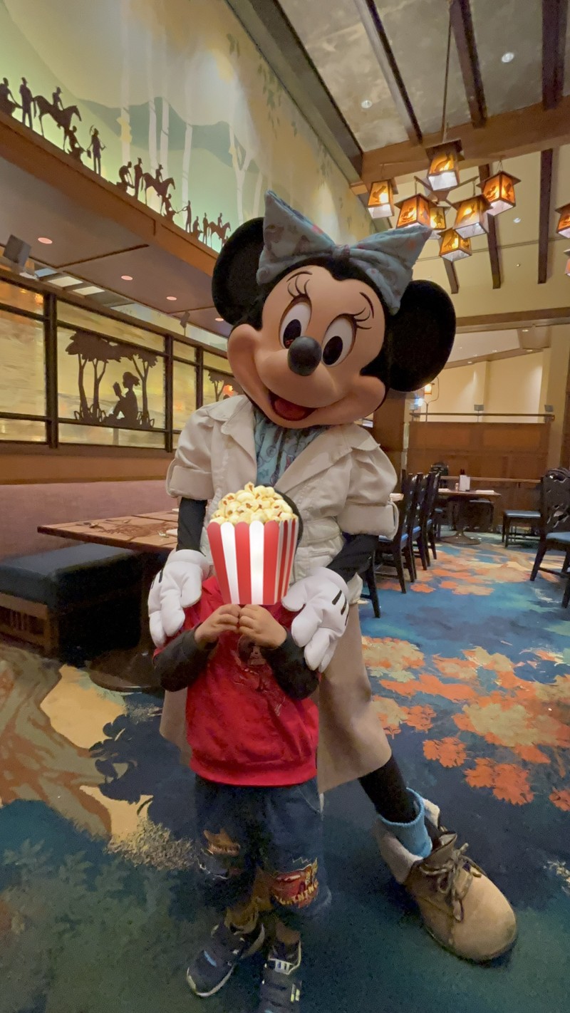 ストーリーテラーズカフェでミニーマウスと息子のグリーティング写真。息子が手でハートを作っている